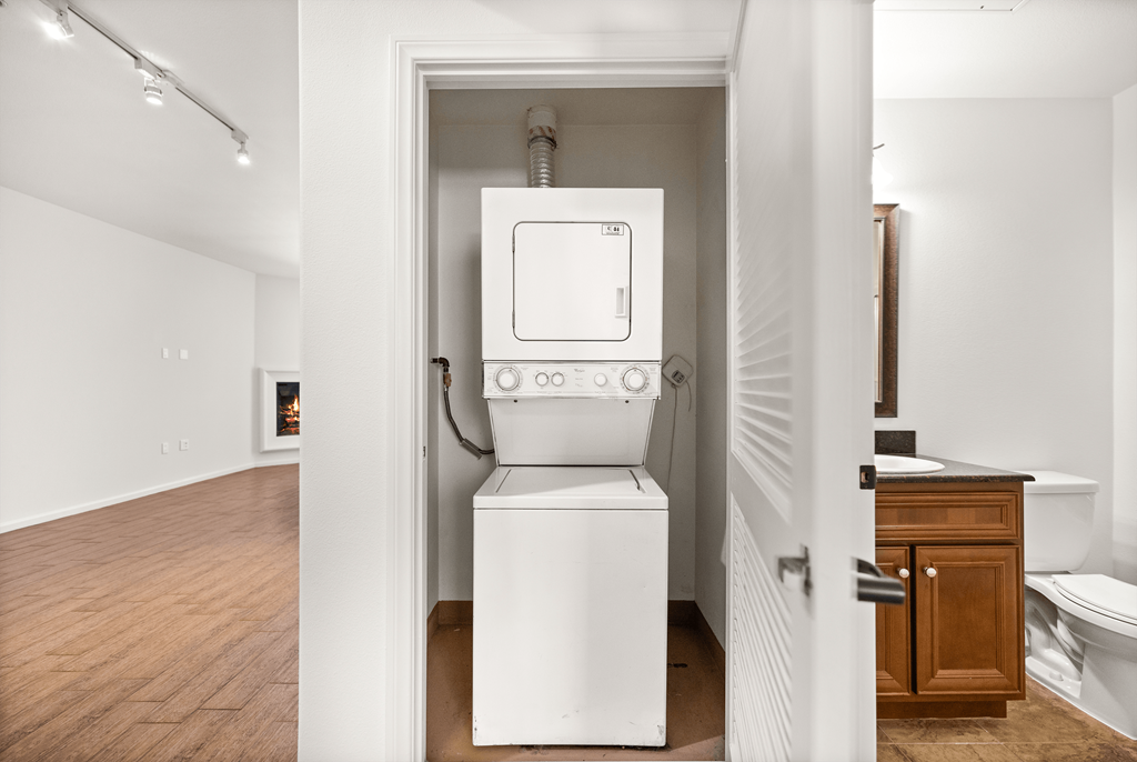 A white toilet is in a small white room.