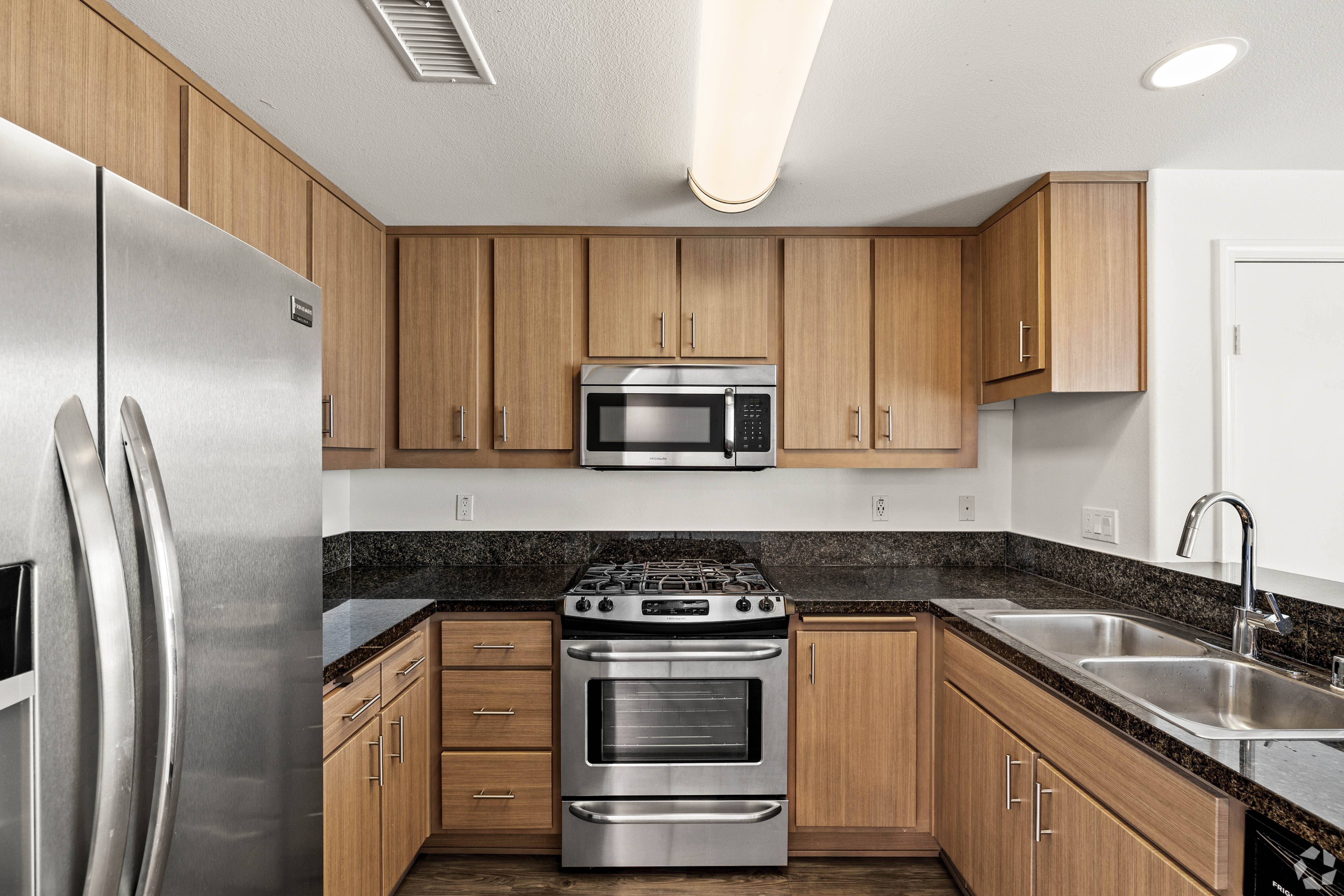 A modern kitchen with wooden cabinets and stainless steel appliances.
