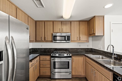 A modern kitchen with wooden cabinets and stainless steel appliances.