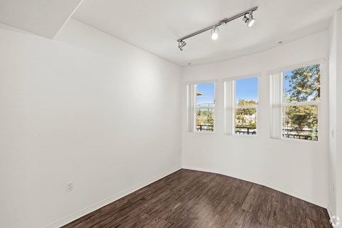 Empty room with white walls and wooden floor.