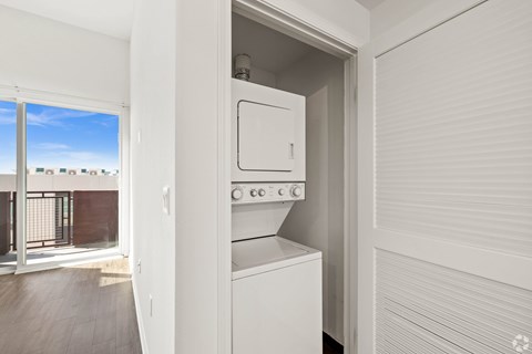 A white oven and microwave are built into a kitchen cabinet.