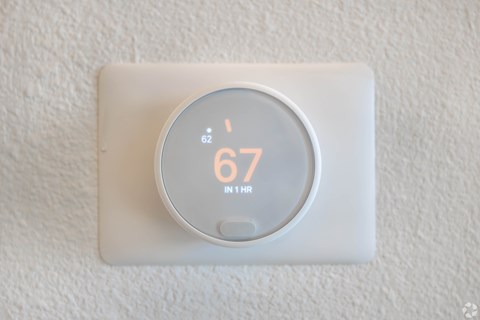 A thermostat showing a temperature of 67 degrees.
