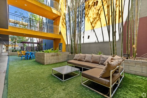 A modern outdoor seating area with a yellow building in the background.