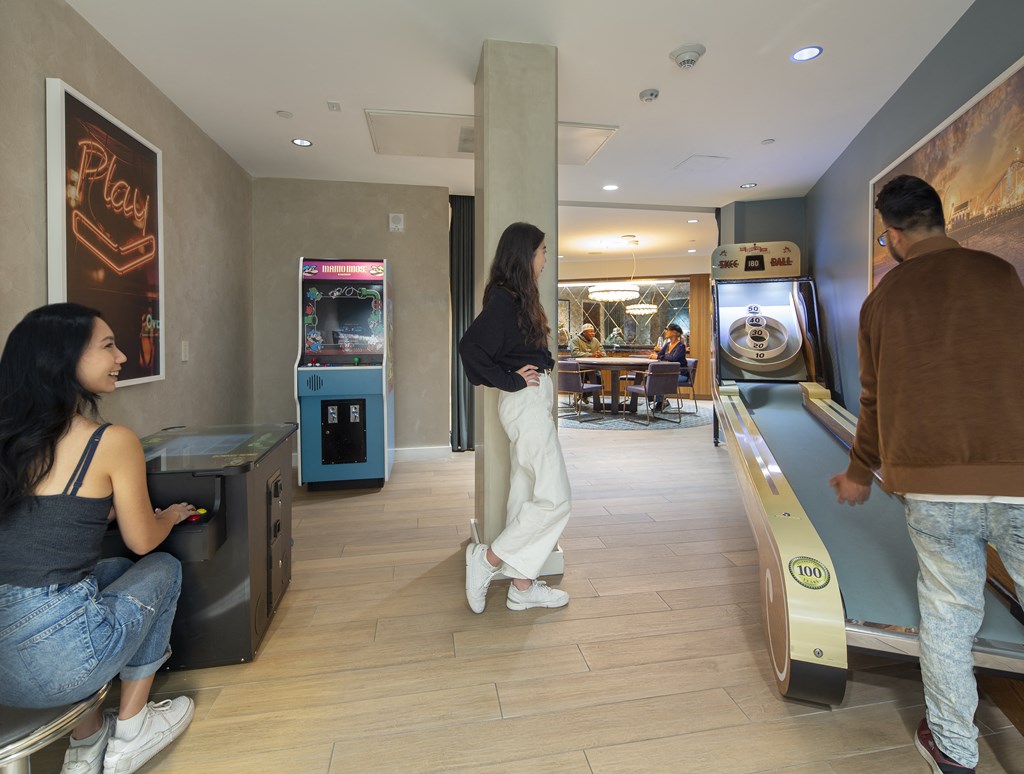 a man and a woman are standing in a room next to a bowling alley