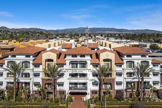 an aerial view of a large apartment complex with palm trees and hills in the background at Le Blanc Apartments, Canoga Park, California, 91304