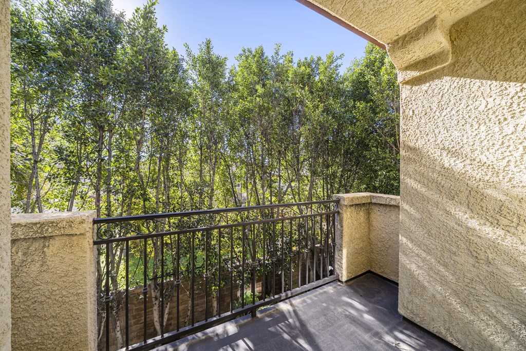 balcony with iron fence looking out to green trees at The Village Apartments, Van Nuys