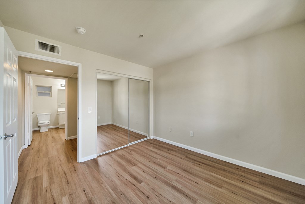 an empty living room with wood flooring and white walls