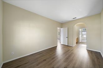 a bedroom with hardwood floors and beige walls at The Village Apartments, Van Nuys, 91406