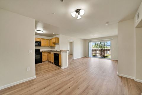 an empty living room and kitchen with a large window at Toscana Apartments, Van Nuys, CA
