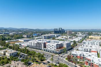 A cityscape with a mix of residential and commercial buildings under a clear blue sky.