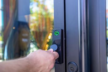 A person is opening a door with a green light on.