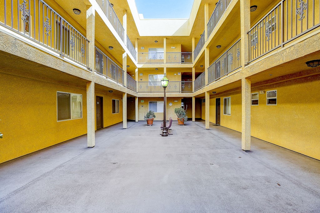 a courtyard with a lamp in the middle of a yellow building