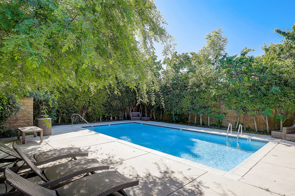 a swimming pool with two chairs next to it
