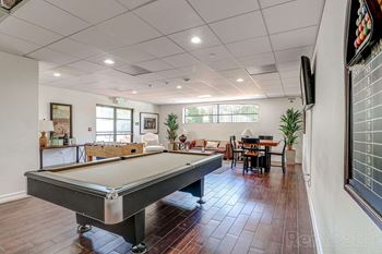 A clubhouse and game room with pool table and foosball at Le Blanc Apartment Homes, California