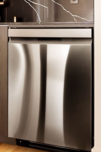A stainless steel refrigerator with a lightning bolt on the wall behind it.