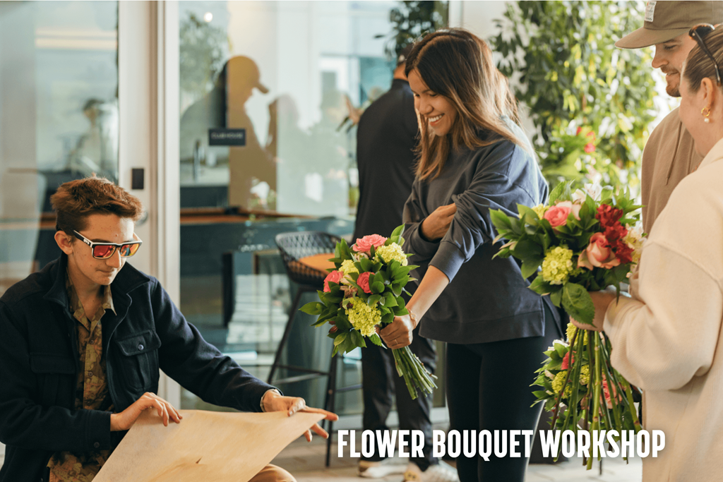 A group of people are gathered around a table with a man pointing at a piece of paper.