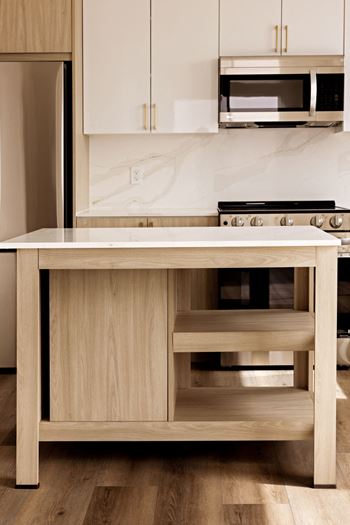 A kitchen with a wooden island and stove top.