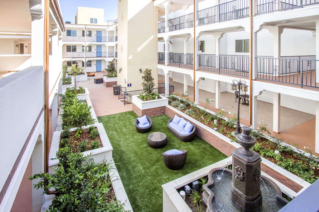 a courtyard with a fountain and green grass at Le Blanc Apartment Homes, California, 91304
