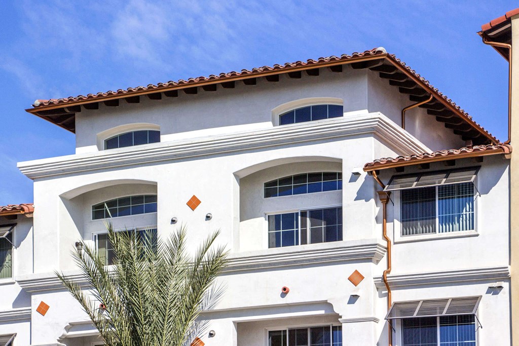a white building with a palm tree in front of it at Le Blanc Apartment Homes, California