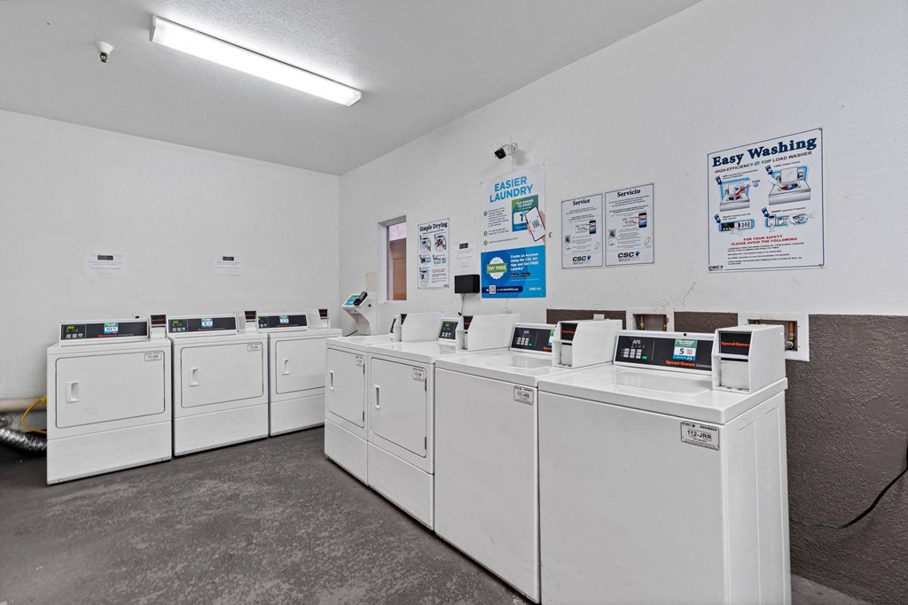 a row of washers and dryers in a laundromat with white machines at Dronfield Astoria, Sylmar, California
