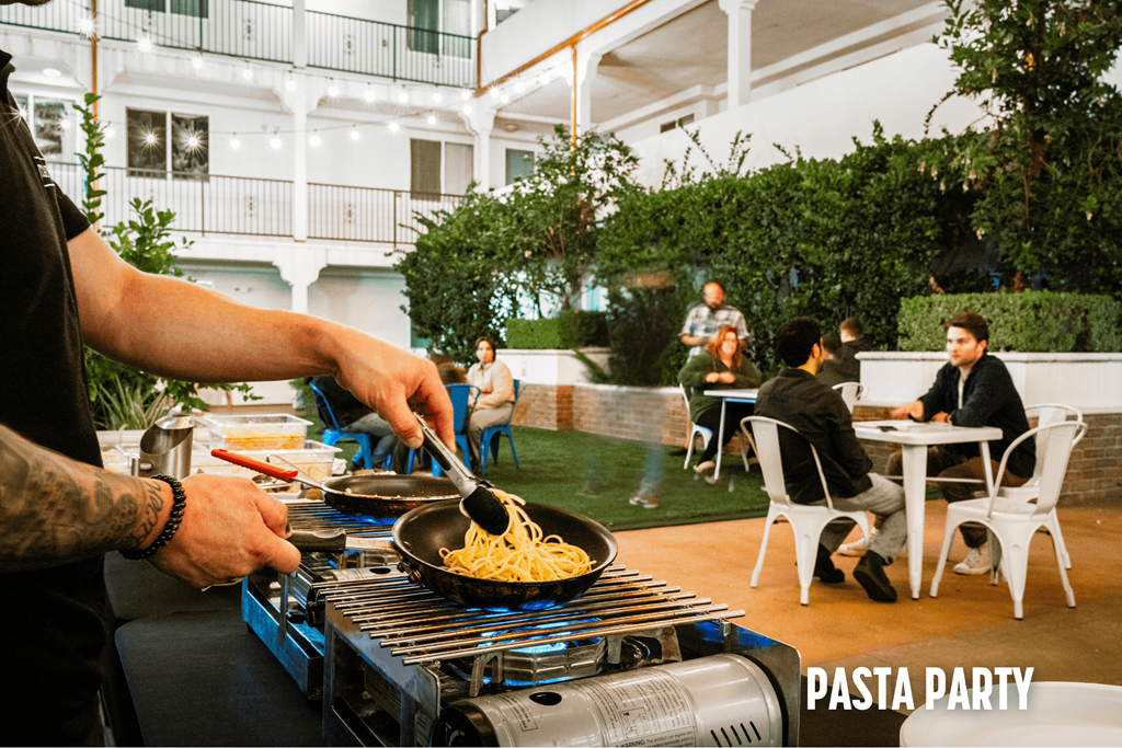 A man is cooking pasta for a pasta party.