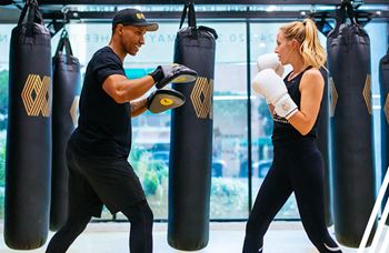 a man and a woman are boxing in a boxing gym