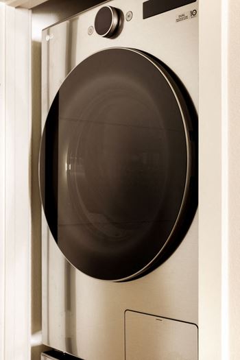 A front-loading washing machine with the door open.