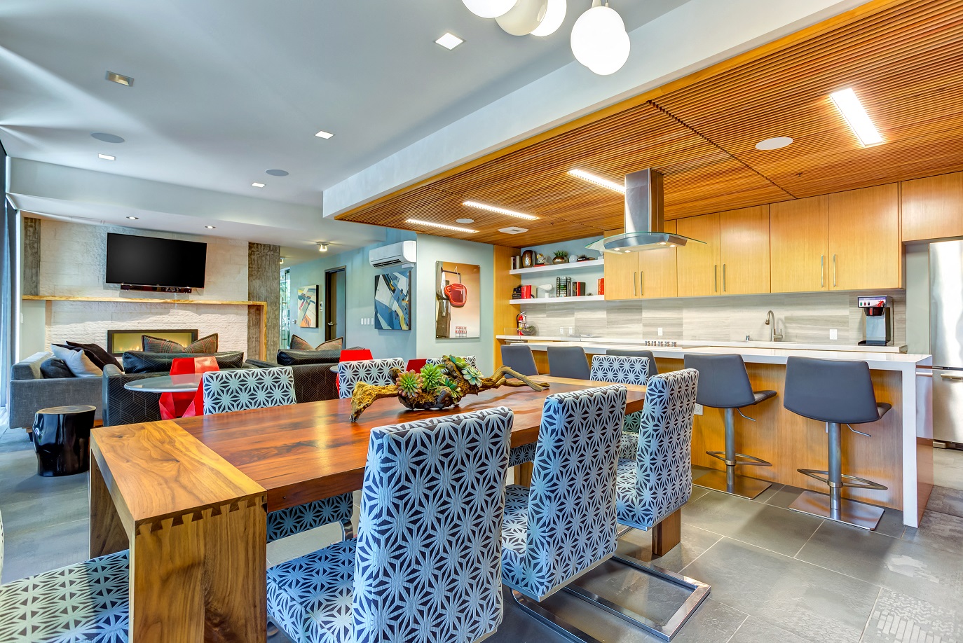 A modern kitchen with a wooden table and chairs in the Aperture clubhouse