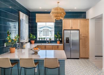 Stainless Steel Appliances and vinyl wood plank flooring at Pillar at Fountain Hills apartments Clubhouse with bar seating and kitchen