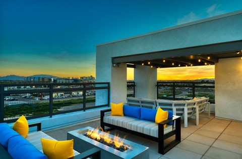 Rooftop patio with tables and chairs and firepit at dusk at Cuvee, Arizona