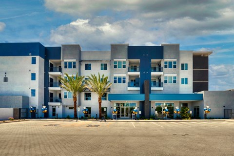 blue and white building of Cuvee with palm trees in front of it at Cuvee, Arizona
