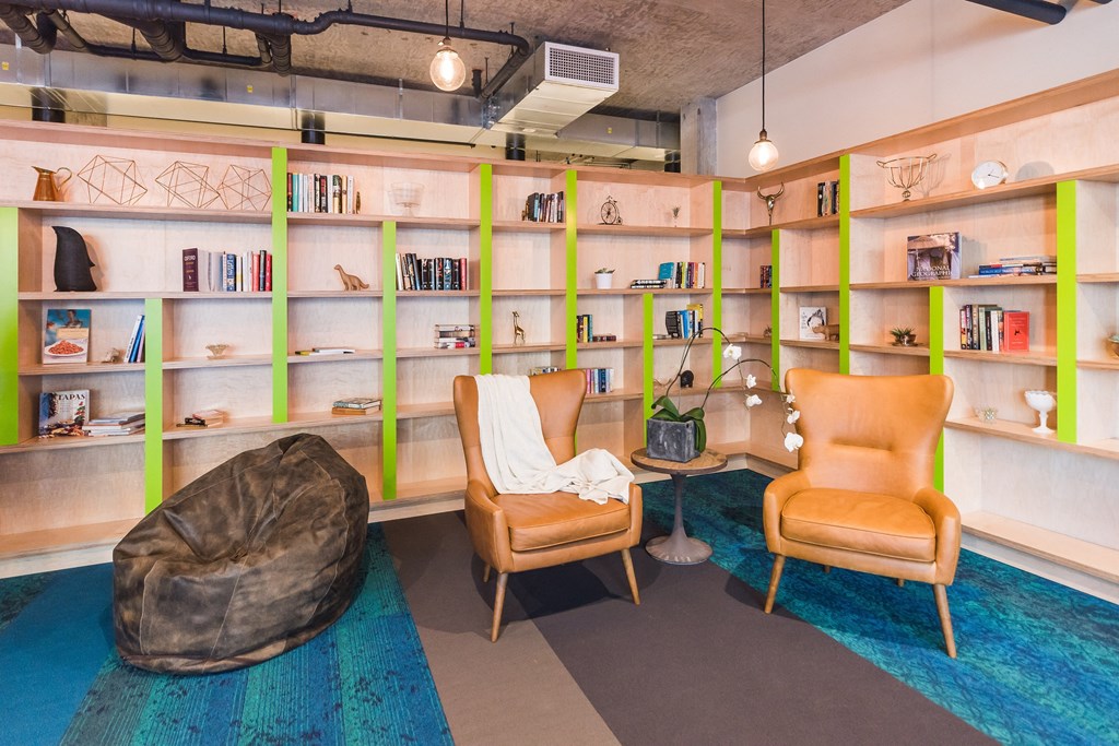 a living room with two chairs and a bookshelf