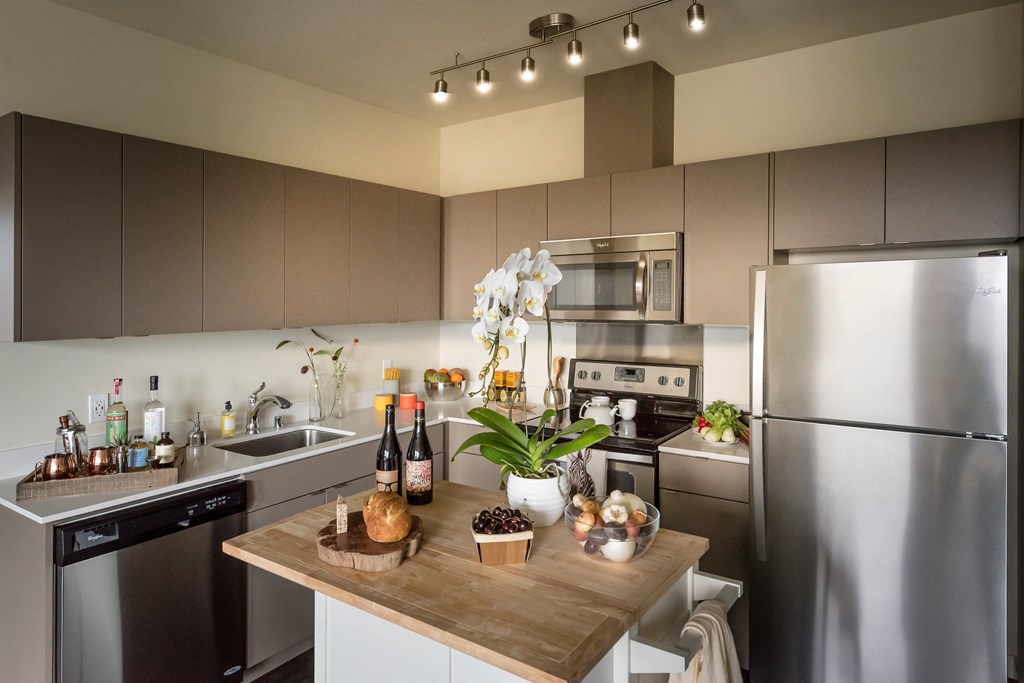 a kitchen with stainless steel appliances and a wooden counter top