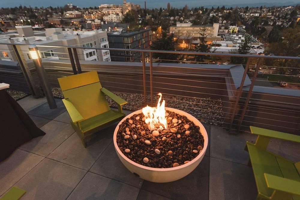 a fire pit on a roof with a city in the background
