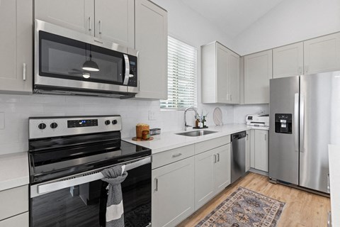 a kitchen with stainless steel appliances and white cabinets