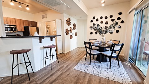 A modern kitchen with a dining table set for four.