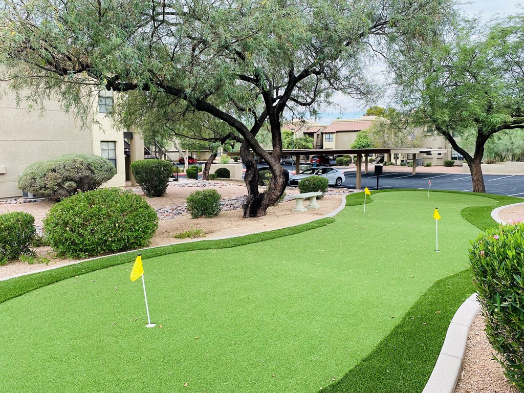 A yellow flag on a putting green.