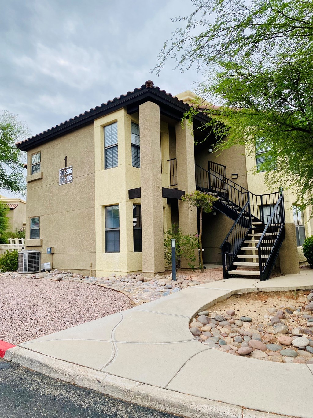 A beige house with a black metal staircase.