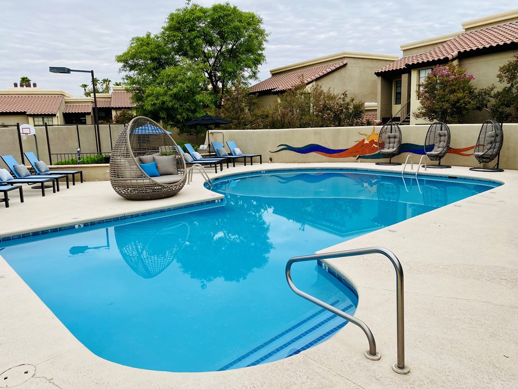 A pool with a blue tinted water and a silver ladder.