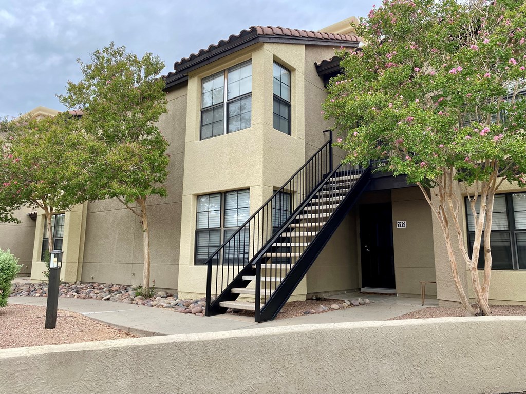 A beige building with a black staircase in front.