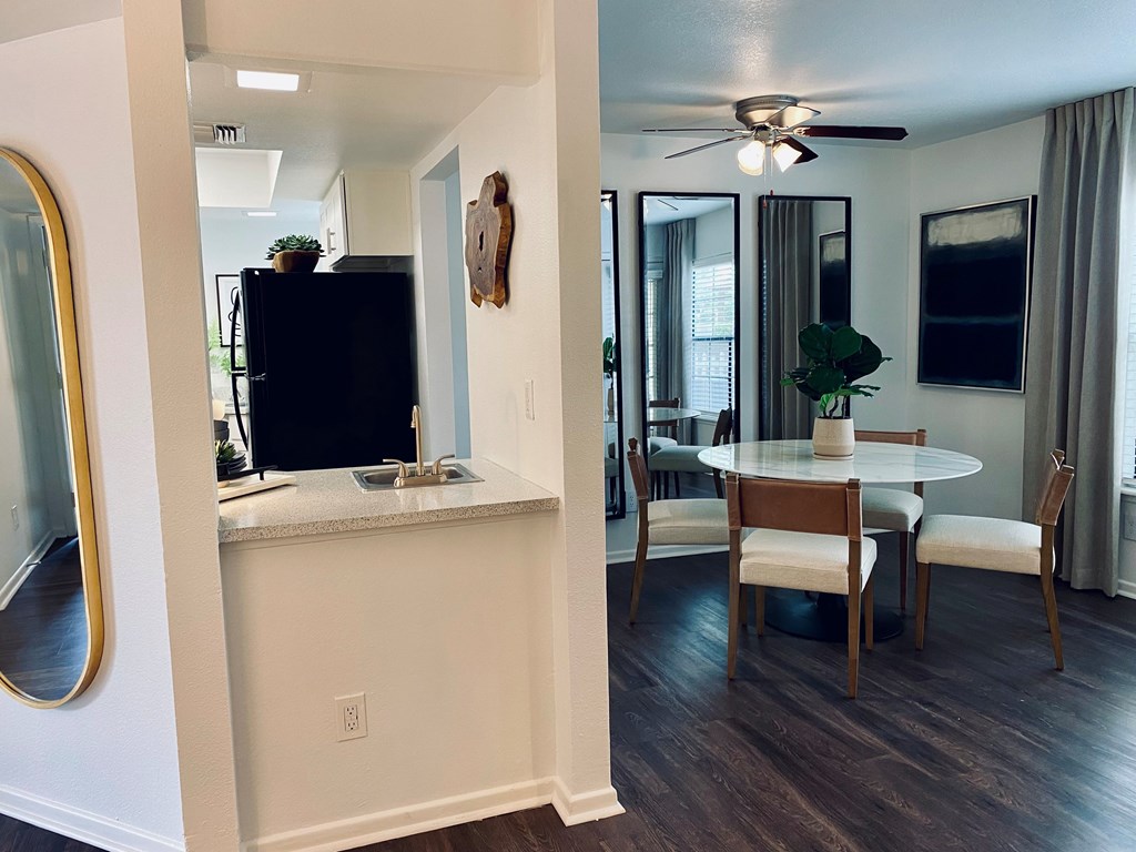 A black television is on a white cabinet in a room with a ceiling fan.