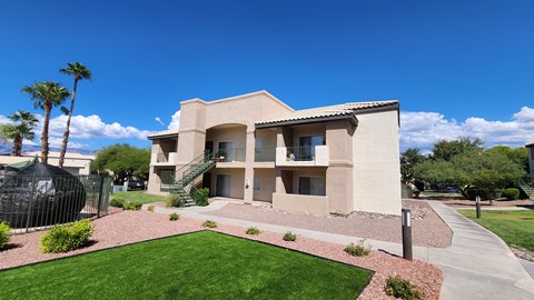 A beige building with a red brick walkway in front.