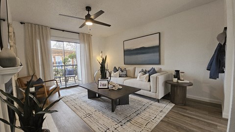 A living room with a white couch, a coffee table, and a painting on the wall.