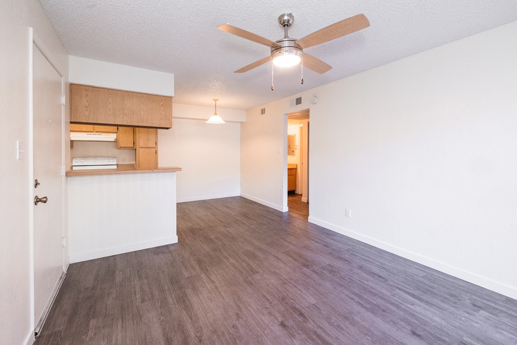 A room with a ceiling fan and wooden flooring.
