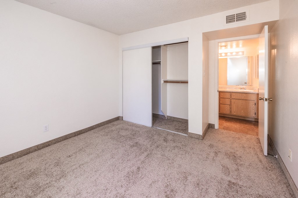 A room with a carpeted floor and a doorway leading to another room.