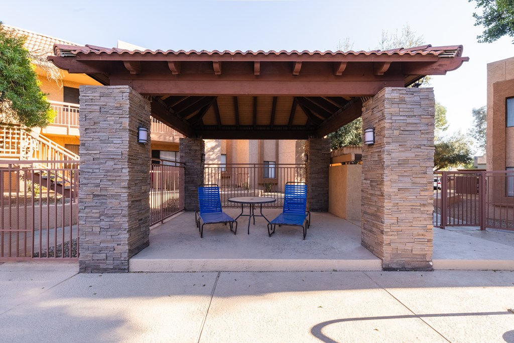 A patio with a table and chairs under a roof.