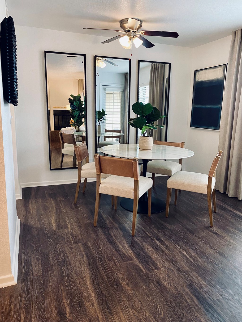 A dining room with a white table and chairs.