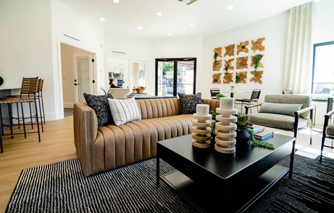A living room with a brown sofa and a black coffee table.