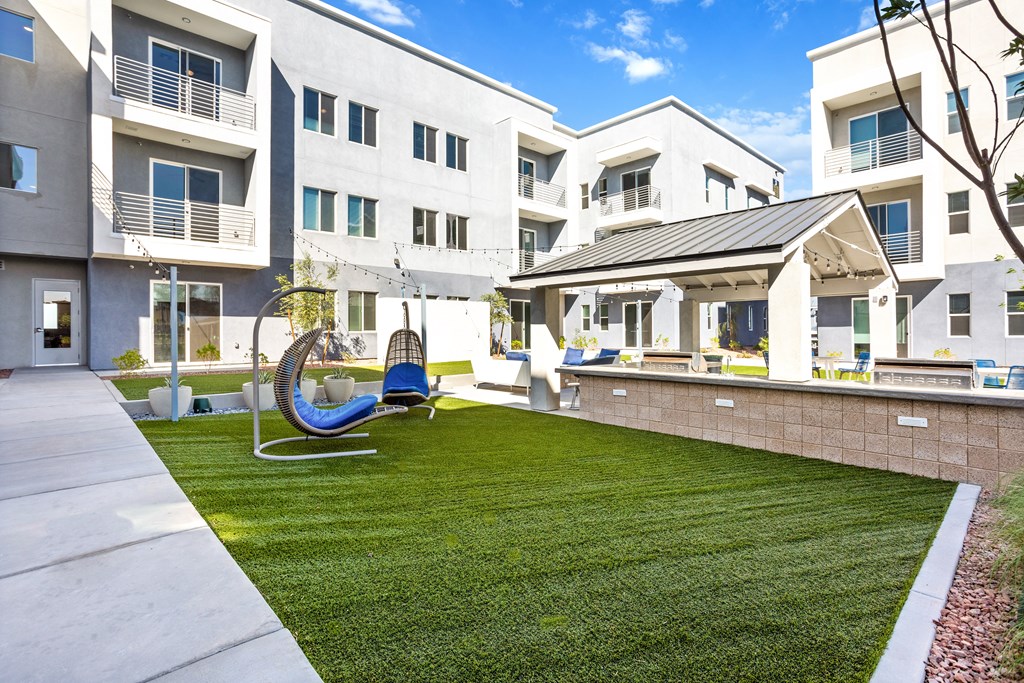 A modern apartment complex with a playground and a slide.