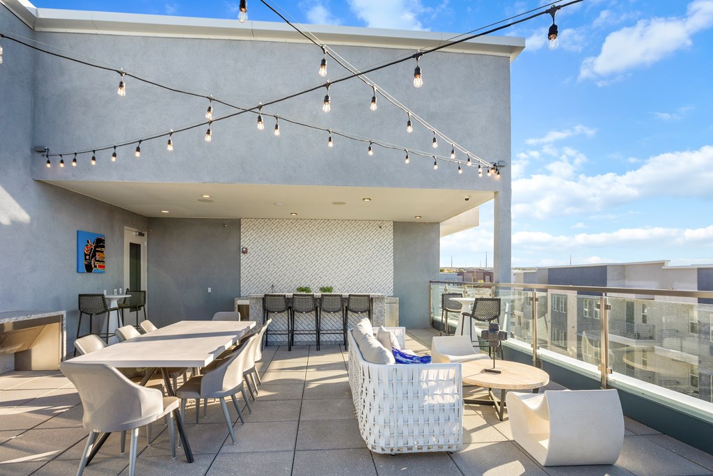 A patio with white furniture and string lights.